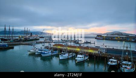 Plusieurs bateaux amarrés à Hyde St Pier et Fishermans Wharf avec brume de coucher de soleil sur l'horizon aérien Banque D'Images