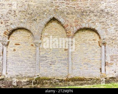 Datant du XIIe siècle, l'église chrétienne de St Michael et tous les Anges avec des arches décoratives sur un mur extérieur, Wadenhoe, Angleterre. Banque D'Images