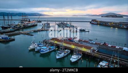 Bateaux amarrés à Hyde St Pier et Fishermans Wharf avec brume de coucher de soleil à l'horizon au-dessus de l'antenne de la baie Banque D'Images