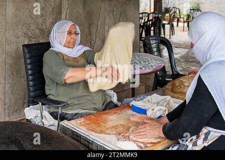 Hurfeish, Israël - 14 août 2023 : deux femmes kurdes préparent du pita frais dans un restaurant kurde à Hurfeish, au nord d'Israël. Banque D'Images