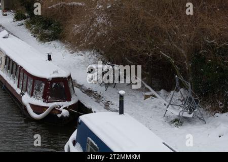 Bateau étroit ou bateau de canal dans la neige sur le canal Kennet et Avon à l'écluse d'Aldermaston. Fait partie de la communauté de croisière continue. Banque D'Images