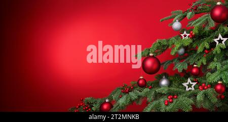 Fond de Noël rouge avec closeup de sapin décoré et espace de copie, avec boules et étoiles Banque D'Images