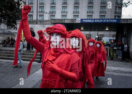 Londres, Royaume-Uni. 19 octobre 2023. La manifestation climatique « Oil Money Out » voit la Red Rebel Brigade rejoindre les militants climatiques de Fossil Free London avant de marcher de Marble Arch à l'Intercontinental Hotel Park Lane pour exiger des changements dans l'industrie des combustibles fossiles. Un Forum sur le renseignement énergétique de trois jours (anciennement la Conférence sur le pétrole et l'argent) se tient actuellement à l'Intercontinental Hotel Park Lane, devant lequel des manifestations ont lieu cette semaine. Crédit : Guy Corbishley/Alamy Live News Banque D'Images