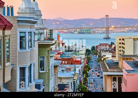Éclairage rose du lever du soleil sur le quartier résidentiel de San Francisco avec Oakland Bay Bridge et vue sur la baie Banque D'Images