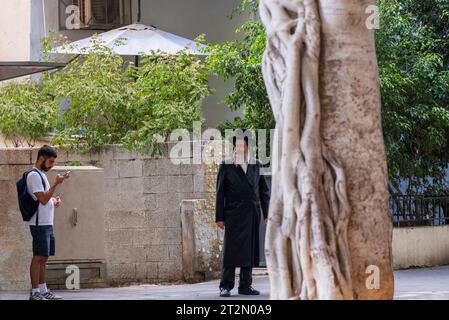 Tel Aviv, Israël - 17 août 2023 : un homme plus âgé hassidique regarde un jeune homme libéral, peut-être désapprouvé, dans le centre-ville de tel Aviv, en Israël Banque D'Images