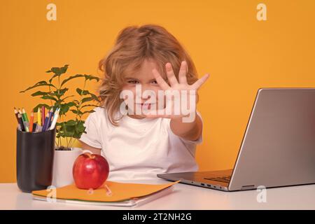 Arrêtez l'intimidation. Un élève triste et en colère. Enfant d'école utilisant un ordinateur portable. Concept d'école et d'éducation. Portrait de l'enfant mignon garçon d'école, isolé sur Banque D'Images