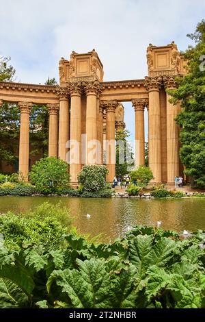 Plantes autour du lagon avec des piliers de colonnade romains antiques et des gens à travers l'eau Banque D'Images