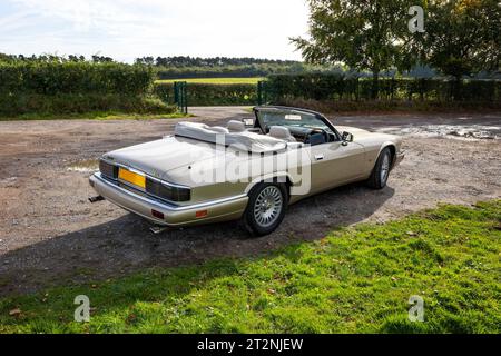 Vue arrière de la Jaguar XJS décapotable avec top down sur un parking en gravier dans le pays Banque D'Images