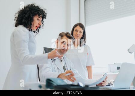 Professionnels de la santé expérimentés discutant des résultats des tests et fournissant des conseils et du soutien à un patient dans une clinique hospitalière. Banque D'Images