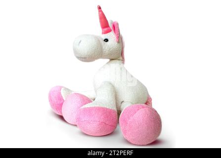 Image d'un jouet licorne souple rose assis sur fond blanc. Image de studio isolée. Photo de haute qualité Banque D'Images