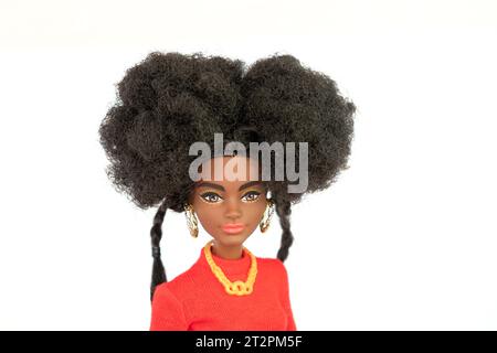 9 octobre 2023. Barnaul, Russie : poupée Barbie afro-américaine avec les cheveux noirs dans un costume rouge debout isolé sur un fond blanc. Banque D'Images