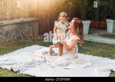 Mère et fille profitant d'un temps ensoleillé dans le jardin. Espace de copie Banque D'Images