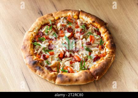 Pizza maison avec des feuilles de cannabis de marijuana sur fond de bois. Marijuana médicale fraîche, cannabis décorer sur pizza. vue de dessus Banque D'Images