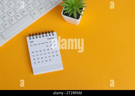 Calendrier de bureau de février 2024 sur fond jaune. Directement au-dessus. Pose à plat. Banque D'Images