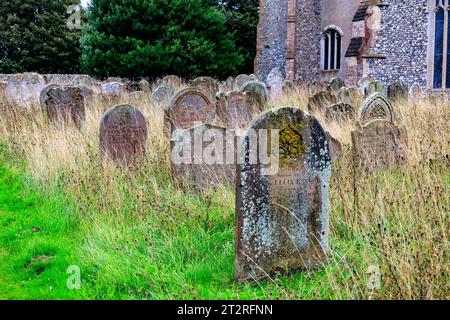 Rangées de pierres tombales dans le cimetière envahi à St Nicholas, Blakeney Parish Church, Norfolk, Angleterre, Royaume-Uni Banque D'Images