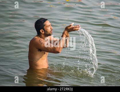 Homme prenant un bain rituel à la rivière Gange à Varanasi Banque D'Images