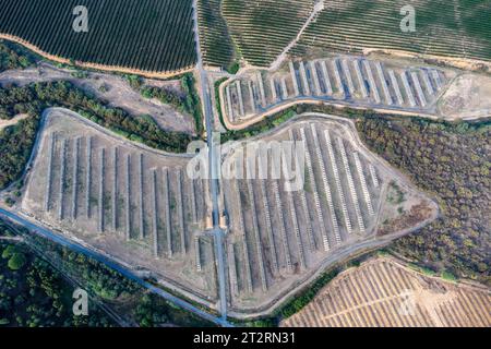 Vue aérienne par drone d'une ferme de panneaux solaires entre les champs de culture Banque D'Images