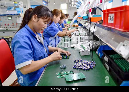 Les femmes portant des combinaisons bleues travaillent sur la chaîne de montage d'une usine qui produit du matériel électrique. Le produit intérieur brut de la Chine a augmenté de 4,9 pour cent en glissement annuel au troisième trimestre, après une hausse de 6,3 pour cent au deuxième trimestre, affichant une reprise régulière malgré les pressions à la baisse, a déclaré mercredi le Bureau national des statistiques. Au cours des trois premiers trimestres, le PIB de la Chine a augmenté de 5,2 pour cent pour atteindre 91,3 billions de yuans (12,5 billions de dollars), après une croissance de 5,5 pour cent au premier semestre de l'année, a déclaré le bureau. (Photo Sheldon Cooper/SOPA Images/Sipa USA) Banque D'Images