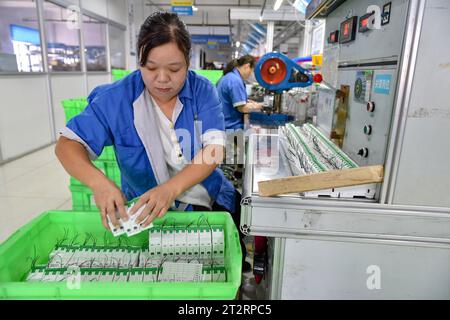 Fuyang, Chine. 18 octobre 2023. Les femmes portant des combinaisons bleues travaillent sur la chaîne de montage d'une usine qui produit du matériel électrique. Le produit intérieur brut de la Chine a augmenté de 4,9 pour cent en glissement annuel au troisième trimestre, après une hausse de 6,3 pour cent au deuxième trimestre, affichant une reprise régulière malgré les pressions à la baisse, a déclaré mercredi le Bureau national des statistiques. Au cours des trois premiers trimestres, le PIB de la Chine a augmenté de 5,2 pour cent pour atteindre 91,3 billions de yuans (12,5 billions de dollars), après une croissance de 5,5 pour cent au premier semestre de l'année, a déclaré le bureau. (Image de crédit : © Sheldon Cooper/SOPA Images via Z) Banque D'Images