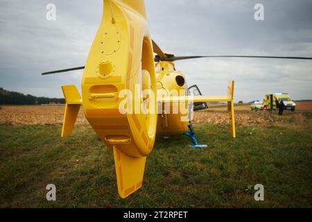 Hélicoptère du service médical d'urgence atterrissant sur le terrain à côté de la route. Coopération entre les équipes ambulance aérienne et paramédicaux au sol. Thèmes sauvetage Banque D'Images