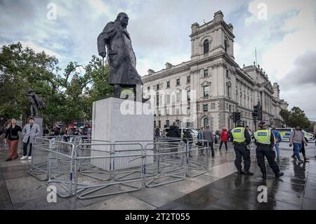 Londres, Royaume-Uni. 21 octobre 2023. La statue de Winston Churchill sur la place du Parlement est entourée de barrières de foule avant une marche pro-palestinienne de masse qui se termine à Whitehall. Crédit : Guy Corbishley/Alamy Live News Banque D'Images