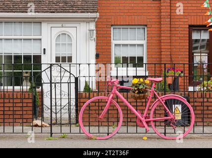DUBLIN, Irlande - 3 août 2023 : Belle maison typique avec un bycicle rose décoratif à l'extérieur de la porte d'entrée Banque D'Images
