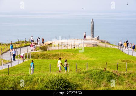 Cricqueville-en-Bessin, France - 6 septembre 2023 : les touristes se promènent sur le chemin de la Pointe du hoc entre les cratères de bombes jusqu'au Monument des Rangers érigé en l'honneur Banque D'Images