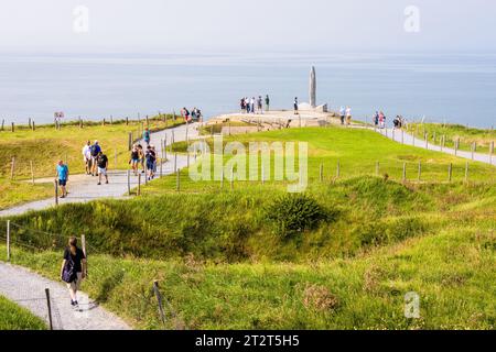 Les touristes se promènent sur le chemin de la Pointe du hoc entre les cratères de bombes jusqu'au Monument des Rangers érigé en l'honneur du sacrifice des troupes américaines le jour J. Banque D'Images