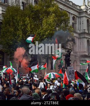 Londres, Royaume-Uni. 21 octobre 2023. Les manifestants grimpent aux feux de circulation avec des drapeaux palestiniens et des fusées éclairantes à Whitehall. Des dizaines de milliers de personnes ont défilé dans le centre de Londres en solidarité avec la Palestine alors que la guerre Israël-Hamas s’intensifie. Crédit : Vuk Valcic/Alamy Live News Banque D'Images