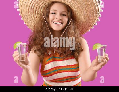 Heureuse femme mexicaine avec tequila sur fond violet Banque D'Images