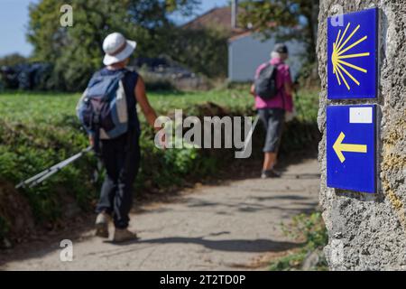 VILLOURIZ, le 4 octobre 2023 : pèlerins sur le chemin de Santiago de Compostella avec un mile marqueur du Camino de Santiago Banque D'Images