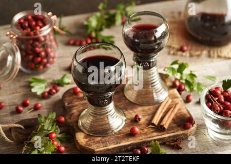 Deux tasses en verre de vin médicinal à base de baies fraîches d'aubépine et d'épices Banque D'Images