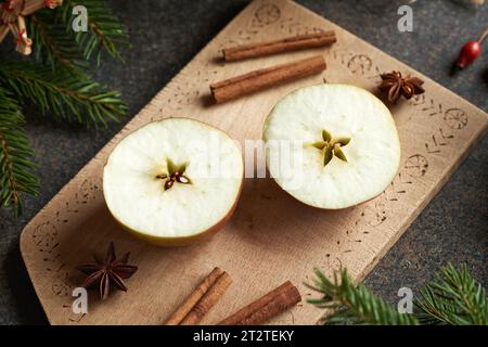 Pomme coupée en deux avec une étoile au milieu, avec épices et décoration de Noël Banque D'Images