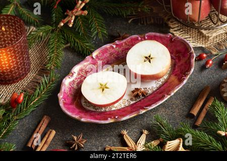 Pomme coupée en deux avec une étoile au milieu, avec épices et décoration de Noël Banque D'Images