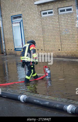 Flensburg, Schleswig-Holstein, Aufräumarbeiten nach Jahrhundert-Hochwasser in Flensburg am Hafen West. Ein Feuerwehrmann beobachtet die Wasserpumpe. Aufnahme vom 21.10.2023, Flensburg, *** Flensburg, Schleswig Holstein, nettoyage après l'inondation du siècle à Flensburg au port ouest Un pompier regarde la pompe à eau Photographie prise 21 10 2023, Flensburg, crédit : Imago/Alamy Live News Banque D'Images