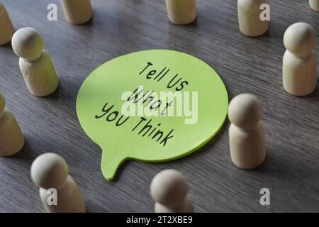 Un groupe de figurines en bois entourant une bulle de discours avec du texte nous DISENT CE QUE VOUS PENSEZ. Entreprise, concept de rétroaction. Banque D'Images