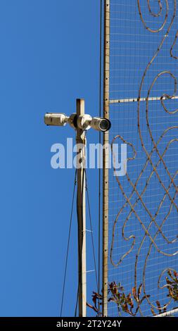 caméra de surveillance extérieure comme fragment d'équipement de rue contre le ciel bleu, image verticale, système de reconnaissance faciale Banque D'Images