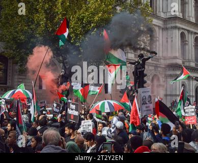 Londres, Royaume-Uni. 21 octobre 2023. Les manifestants grimpent aux feux de circulation avec des drapeaux palestiniens et des fusées éclairantes à Whitehall. Des dizaines de milliers de personnes ont défilé dans le centre de Londres en solidarité avec la Palestine alors que la guerre Israël-Hamas s’intensifie. Crédit : Vuk Valcic/Alamy Live News Banque D'Images