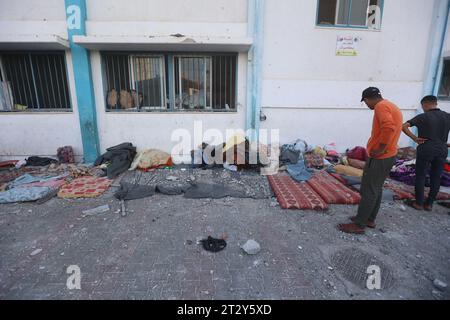 Gaza, Palestine. 21 octobre 2023. Les Palestiniens inspectent les débris après une frappe israélienne près d’une école de l’Office de secours et de travaux des Nations Unies pour les réfugiés de Palestine (UNRWA) à Khan Yunis, dans le sud de la bande de Gaza. Crédit : SOPA Images Limited/Alamy Live News Banque D'Images