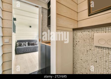 l'intérieur d'une petite maison avec des lambris de bois et des carreaux blancs sur les murs il y a un miroir dans la porte Banque D'Images