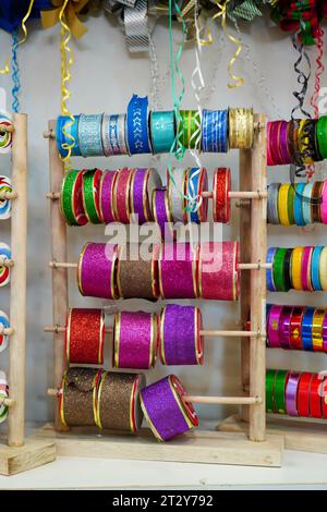 Collection de rubans cadeaux colorés : une gamme d'options vibrantes disposées sur un présentoir de magasin Banque D'Images