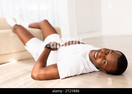 Homme noir millénaire athlétique faisant des exercices pour les abdominaux à la maison Banque D'Images