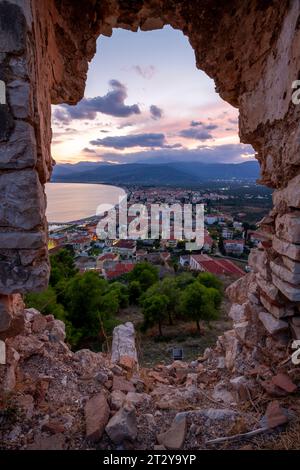 Vue panoramique sur la ville côtière Paralio Astros au coucher du soleil, à travers un bastion du château médiéval (17e s.) qui surplombe la ville. Banque D'Images