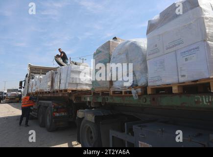 Gaza, Palestine. 21 octobre 2023. Des employés de la Société palestinienne du Croissant-Rouge reçoivent le convoi d'aide du côté égyptien, à la frontière de Rafah. L'agence des Nations Unies (ONU) devrait fournir une aide humanitaire à ceux qui en ont besoin dans diverses zones de la bande de Gaza, a déclaré samedi le bureau des médias du gouvernement de Gaza. Crédit : SOPA Images Limited/Alamy Live News Banque D'Images