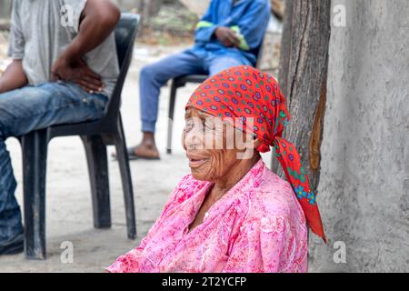 vieille femme de village africain avec famille situé sur le sol en face de la maison Banque D'Images