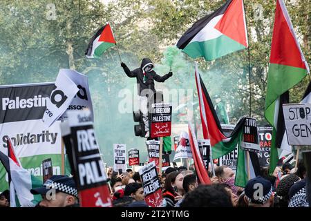 Londres, Royaume-Uni. 21 octobre 2023. Un manifestant allume une flamme de fumée pendant l'assemblée de Westminster. Après la première marche du 7 octobre, environ 100 000 manifestants pro-palestiniens, revendiqués par la police métropolitaine, se sont joints à une marche dans le centre de Londres pour manifester leur solidarité avec les Palestiniens et appeler à la fin du bombardement israélien de Gaza. Les manifestants se rassemblent à Marble Arch et marchent jusqu'à la place du Parlement. (Photo Daniel Lai/SOPA Images/Sipa USA) crédit : SIPA USA/Alamy Live News Banque D'Images