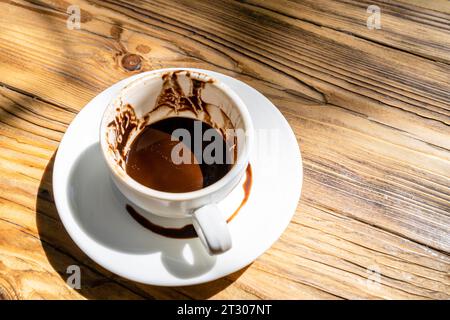 Au-dessus de vieiw de tasse de café turc avec des motifs et des motifs laissés après avoir bu sur la soucoupe pour dire la fortune sur la table en bois dans le café de rue au soleil Banque D'Images