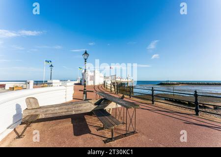 Le banc et la table Army Johnson en forme de biplan en bois sur le front de mer de Herne Bay devant la jetée. Journée ensoleillée, avec ciel bleu. Banque D'Images