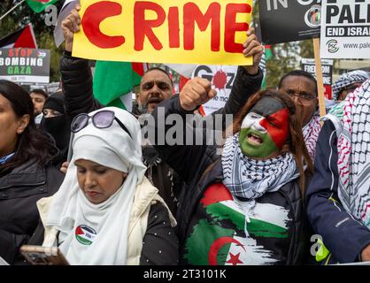 Londres / Royaume-Uni - 21 2023 octobre : une manifestante pro-palestinienne avec son visage peint en couleurs de drapeau palestinien crie lors d'une manifestation de masse contre Banque D'Images