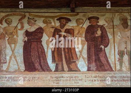 Squelettes souriants avec une femme et trois hommes, chacun percés par la flèche de la mort : une reine ; un barbu portant un chapeau plat rond ; un homme portant un bocal ; et un soldat en armure. Détail de la frise fresque de danse de la mort de la Renaissance, peinte en 1539 par Simone II Baschenis (c. 1495-1555), sur un mur extérieur de la Chiesa di San Vigilio, Pinzolo, Trentin-Haut-Adige, Italie. Banque D'Images